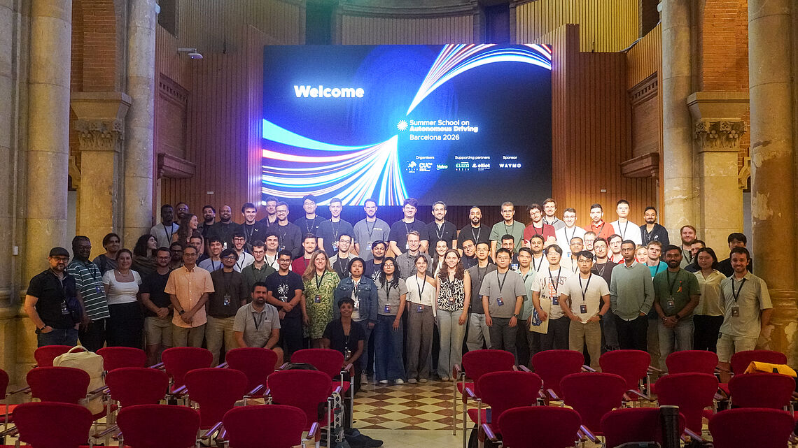 Gruppenfoto der Teilnehmenden der ELLIS Summer School on Autonomous Driving in einem Veranstaltungsraum in Barcelona.