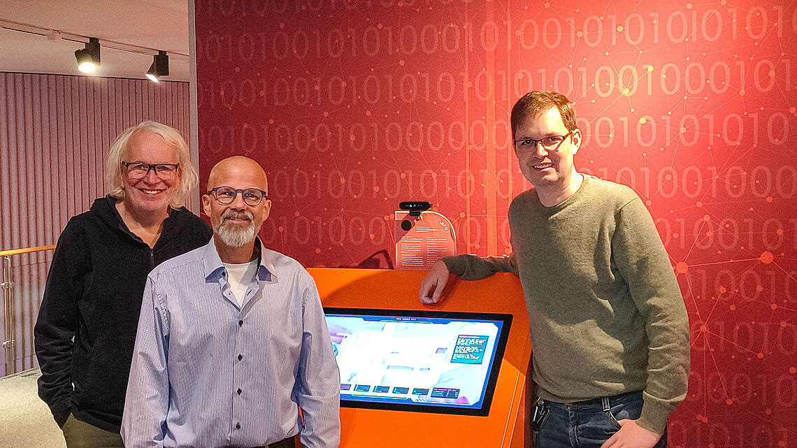 Gemeinsam für den Transfer von der Hochschule ins Museum: Prof. Dr. Markus Lange-Hegermann mit Ralph Burmester und Jörg Bradenahl vom Deutschen Museum Bonn vor dem neuen Demonstrator der KI-Akademie OWL.