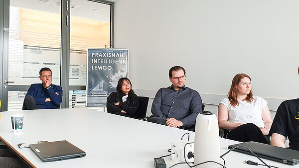 Prof. Dr. Henning Trsek und seine Forschungsgruppe "Vernetzte Automatisierungssysteme" verfolgen die Abschlusspräsentation von Marlon Marx.