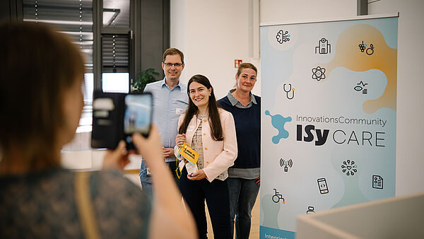 Prof. Dr. Markus Lange-Hegermann, Dr. Laura Moradbakhti und Marianne Petersmeier stehen nach dem erfolgreichen Pitch von RehAI-SCAN nebeneinander.